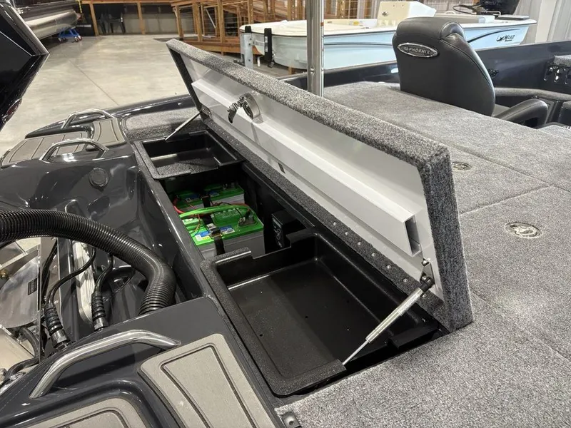 Slide: The Image of Open storage compartment in 2025 Phoenix 721 ZXL boat, revealing batteries and interior details. - 24