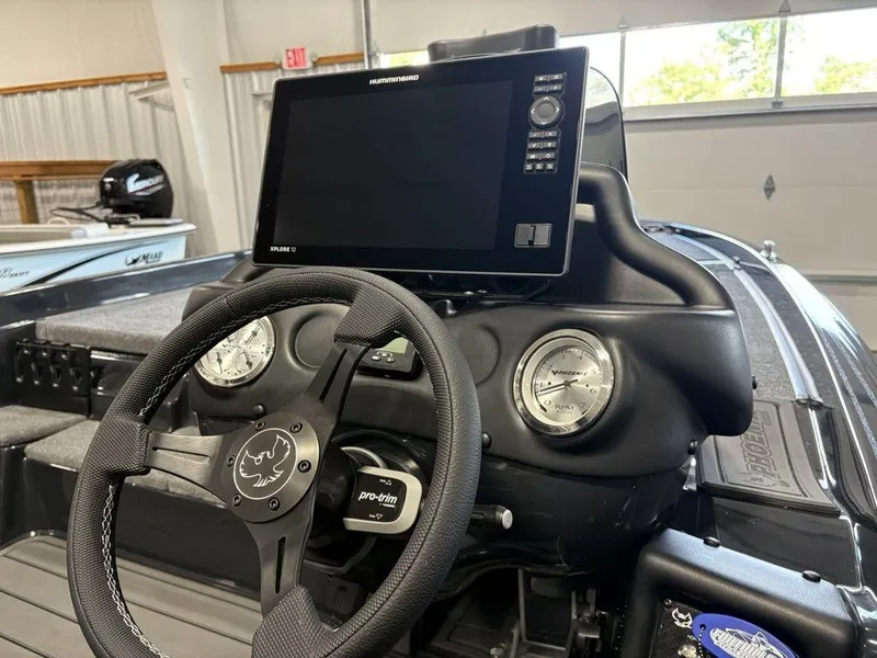 Slide: The Image of 2025 Phoenix 721 ZXL boat dashboard with steering wheel and Humminbird XPLR 12 display. - 25