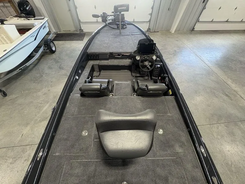 Slide: The Image of 2025 Phoenix 721 ZXL boat interior with steering console and seating in a garage. - 26
