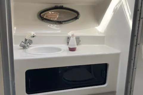 Slide: The Image of 1997 Chaparral 31 boat bathroom with sink, faucet, and oval window. - 10