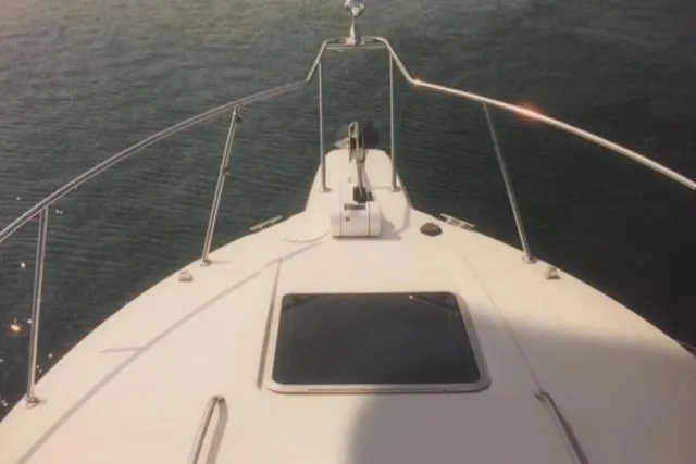 Slide: The Image of Bow view of a 1997 Chaparral 31 boat on calm water. - 2