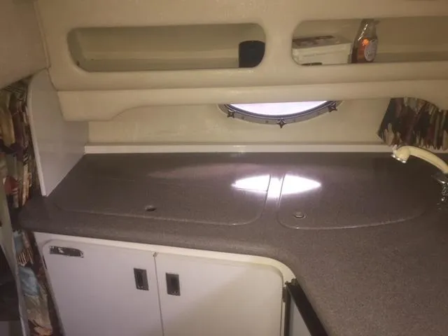 Slide: The Image of 1997 Chaparral 31 boat interior with countertop, sink, and storage cabinets. - 7