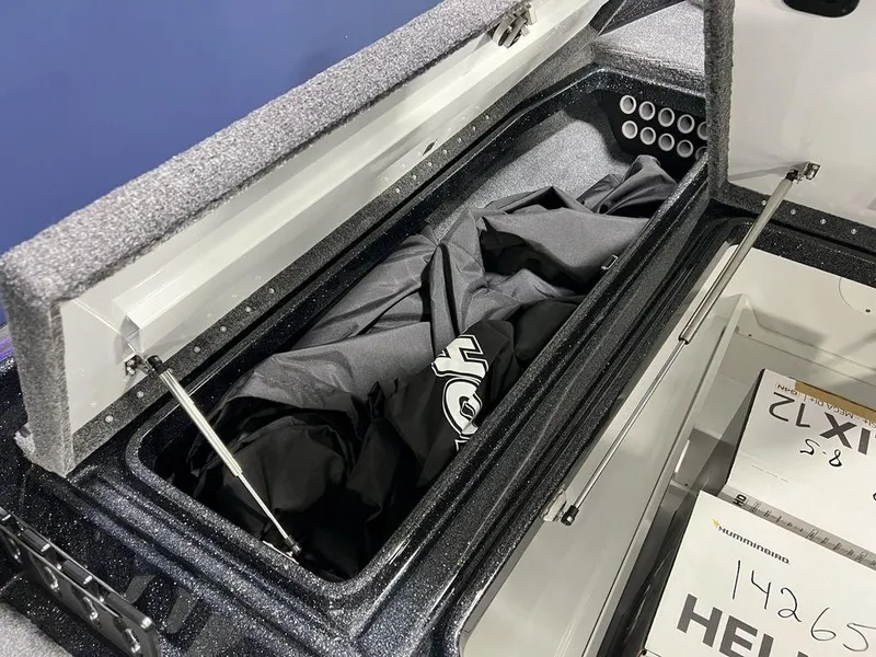 Slide: The Image of Open storage compartment in a 2025 Phoenix 920 Elite boat, containing a black fabric item. - 13