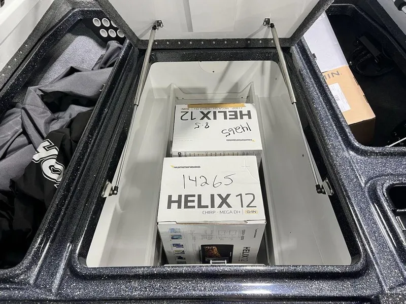 Slide: The Image of Open storage compartment in Phoenix 920 Elite 2025 boat with Helix 12 boxes inside. - 19