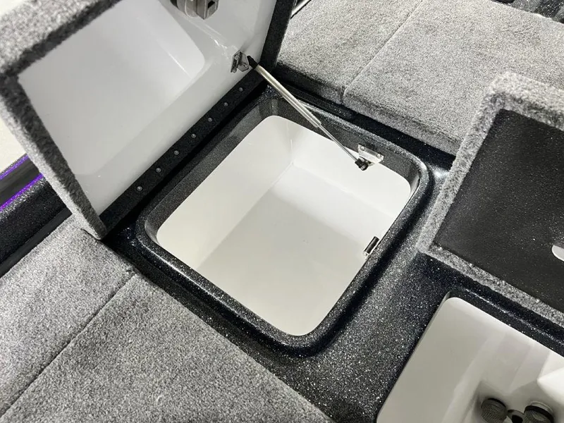 Slide: The Image of Open storage compartment in 2025 Phoenix 920 Elite boat, featuring carpeted interior. - 23