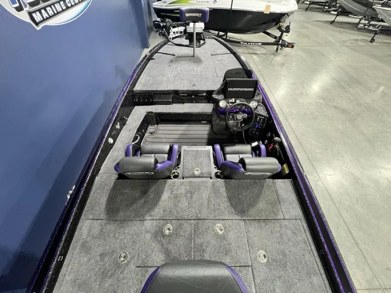 Slide: The Image of 2025 Phoenix 920 Elite boat interior with steering console and seating, displayed in a showroom. - 25