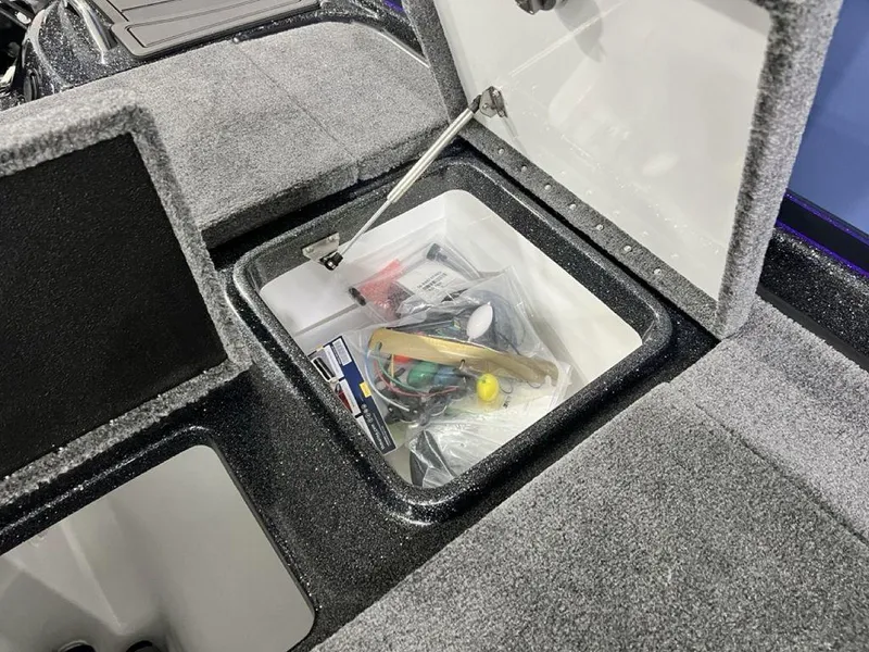 Slide: The Image of Open storage compartment in 2025 Phoenix 920 Elite boat, containing various tools and accessories. - 29