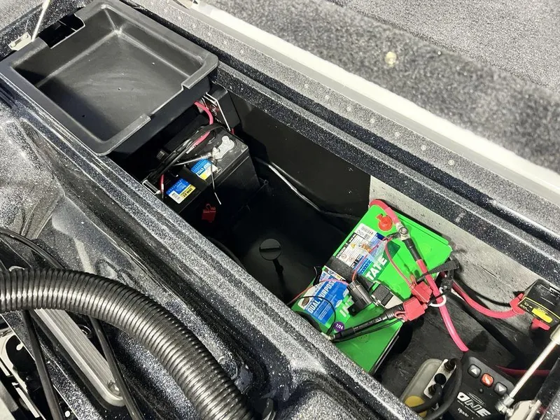 Slide: The Image of Battery compartment of 2025 Phoenix 920 Elite boat, showing wiring and storage space. - 30