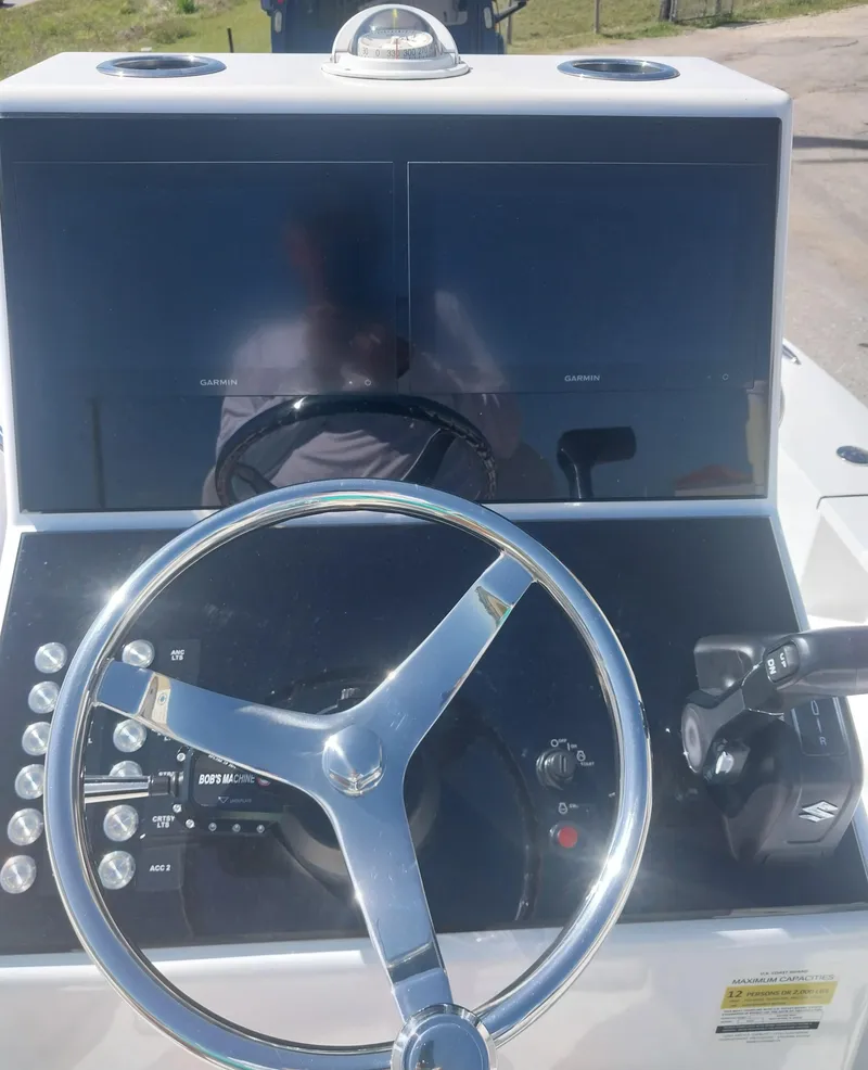 Slide: The Image of 2024 Savage Seas Shallow Bay SS22 boat dashboard with steering wheel and controls. - 12