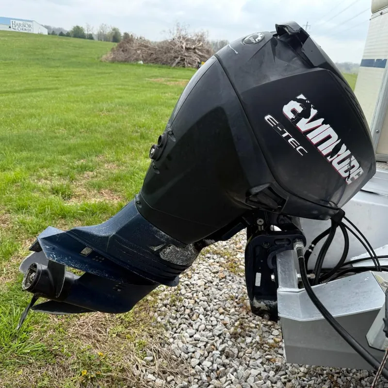 Slide: The Image of Outboard motor on a 2007 Godfrey Aqua Patio 200 RE 3, parked on gravel. - 6