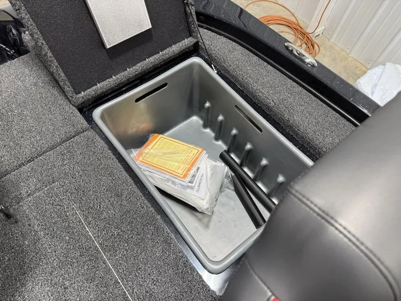 Slide: The Image of Storage compartment in a 2025 Nitro Z18 Pro boat, containing manuals and accessories. - 19