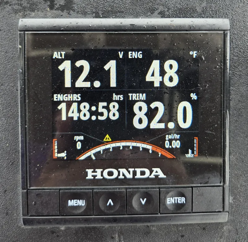 Slide: The Image of Honda engine display showing voltage, engine hours, and trim percentage. Mako 231, 1994 model. - 1