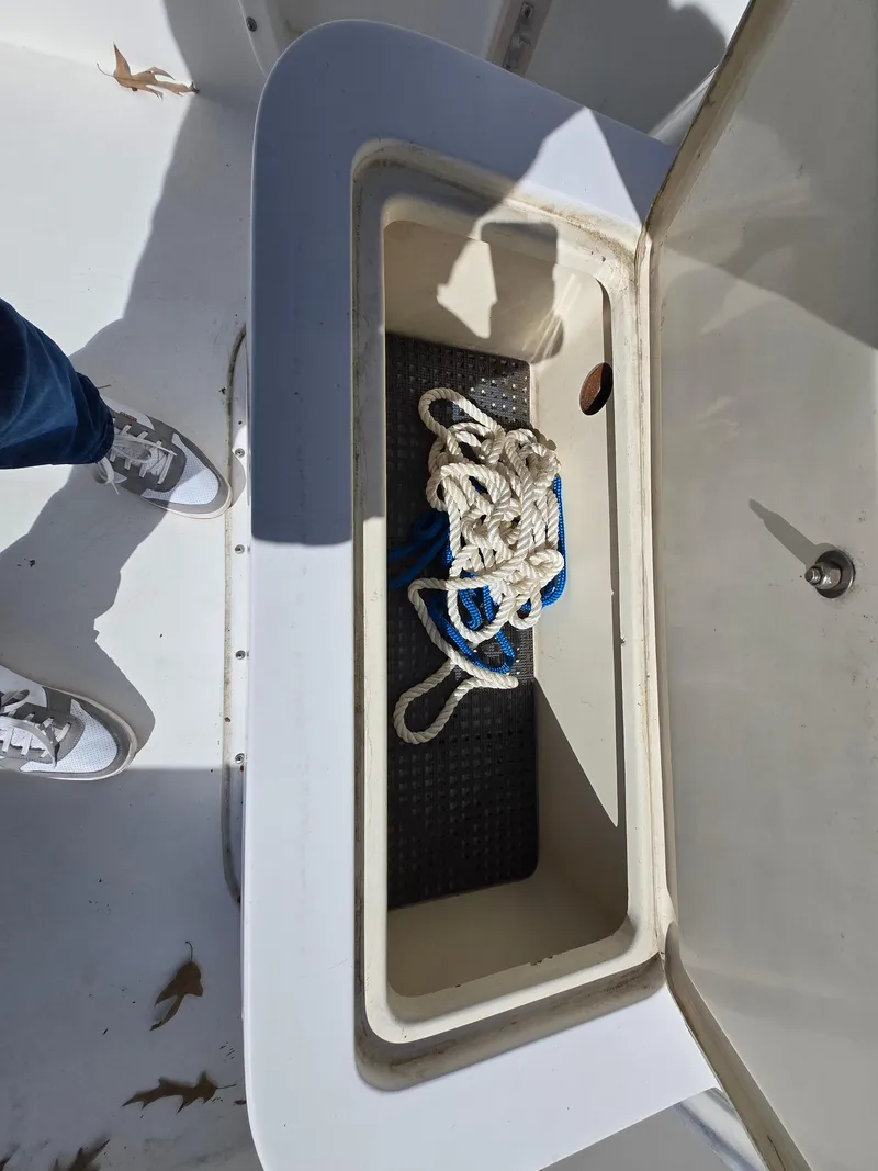 Slide: The Image of Open storage compartment on a 1994 Mako 231 boat with rope inside. - 13
