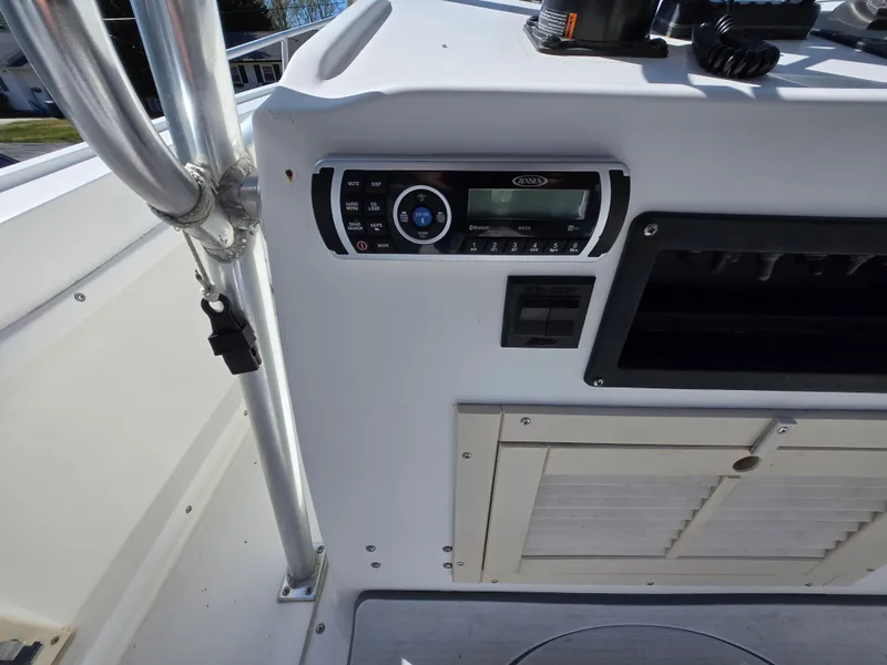 Slide: The Image of 1994 Mako 231 boat dashboard with radio controls and storage compartment. - 14