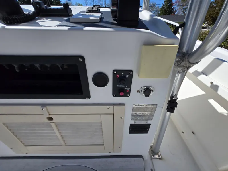 Slide: The Image of 1994 Mako 231 boat dashboard with controls and storage compartment. - 15