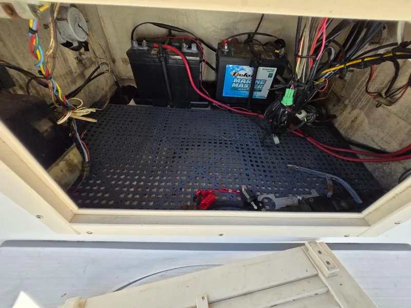 Slide: The Image of Electrical compartment of a 1994 Mako 231 boat with batteries and wiring. - 16
