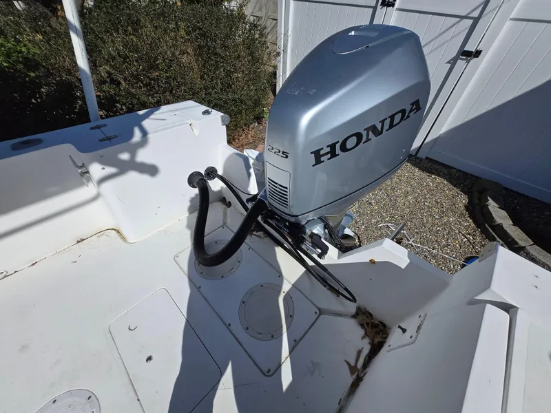 Slide: The Image of 1994 Mako 231 boat with Honda outboard motor in a sunny outdoor setting. - 17
