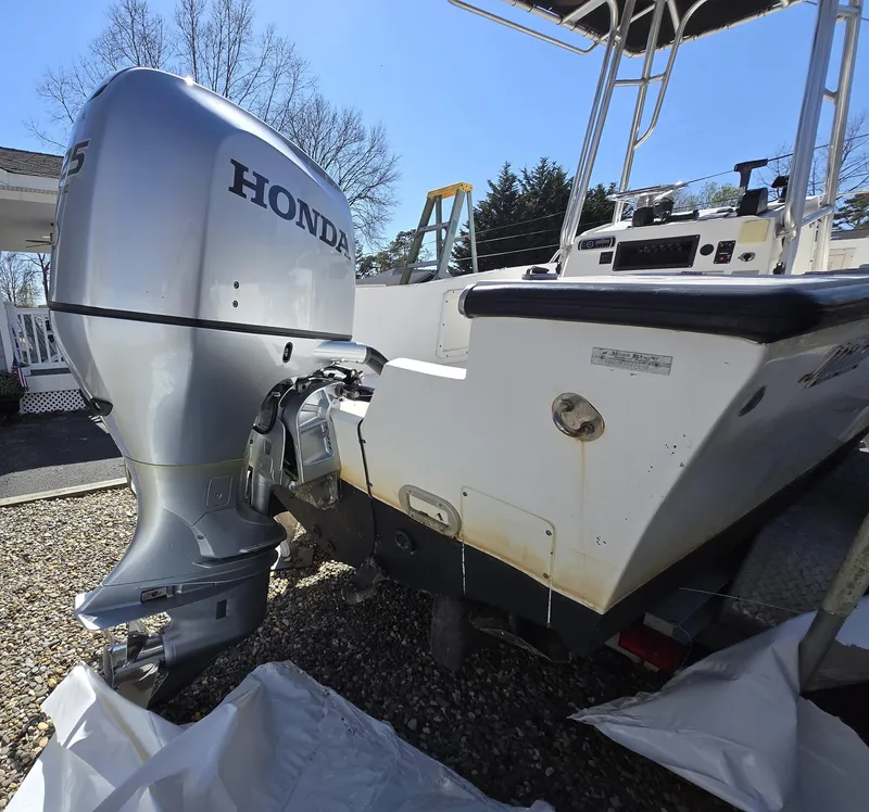 Slide: The Image of 1994 Mako 231 boat with Honda outboard motor, parked on gravel. - 20