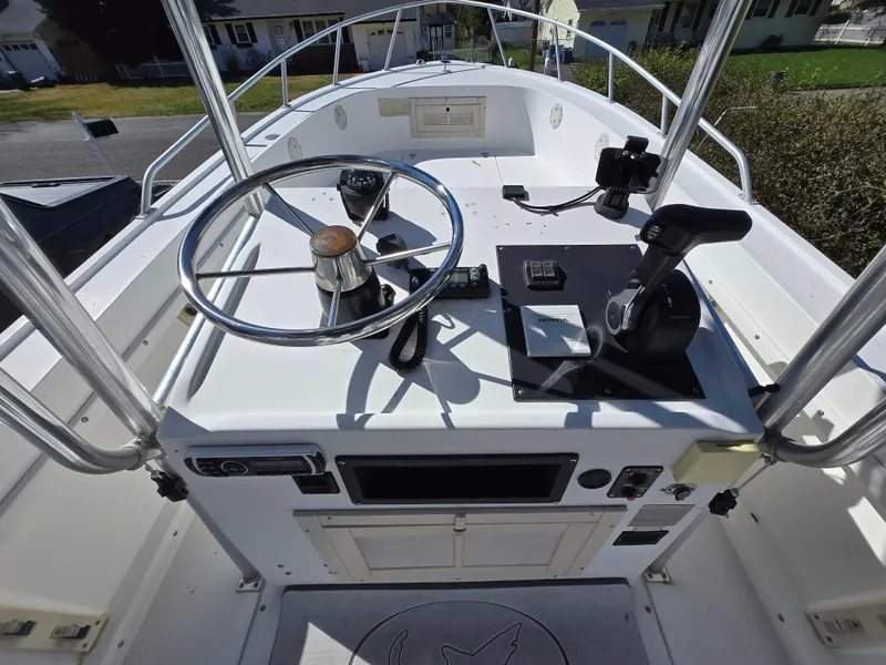 Slide: The Image of 1994 Mako 231 boat dashboard with steering wheel and controls, featuring a clean, white design. - 6