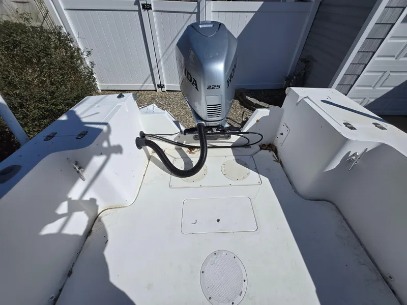 Slide: The Image of 1994 Mako 231 boat interior with Honda 225 outboard motor, white deck, and storage compartments. - 7