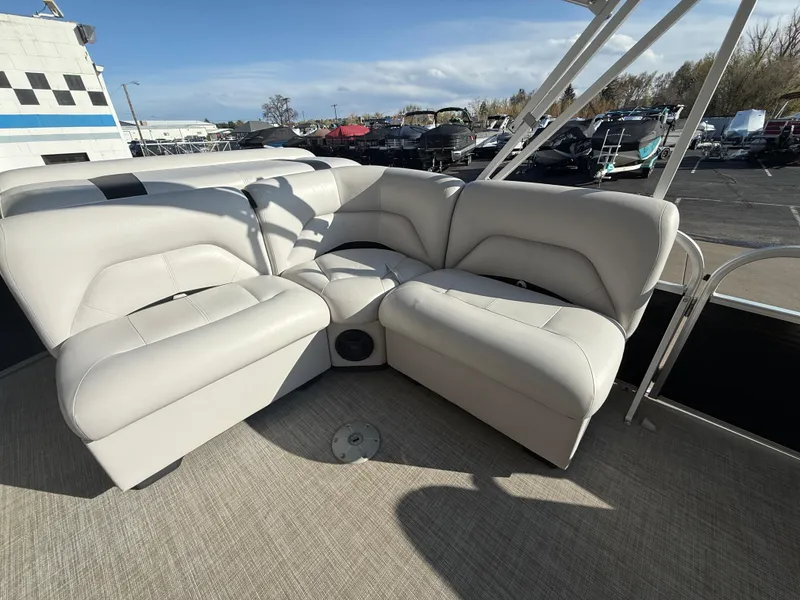 Slide: The Image of 2018 Landau Island Breeze 212C pontoon boat with beige seating and carpeted deck. - 12