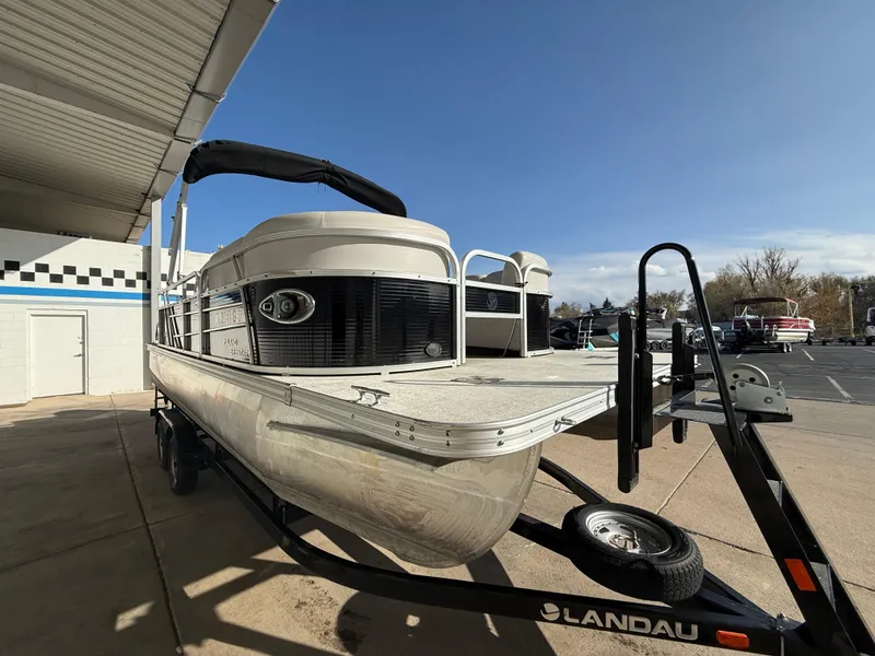 Slide: The Image of 2018 Landau Island Breeze 212C pontoon boat on trailer under a canopy. - 3