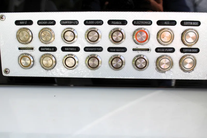 Slide: The Image of Control panel of a 2007 Yellowfin 36 Offshore boat with labeled switches. - 19