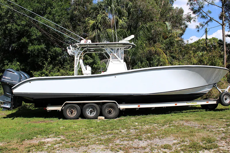 Slide: The Image of 2007 Yellowfin 36 Offshore boat on trailer, surrounded by lush greenery. - 46