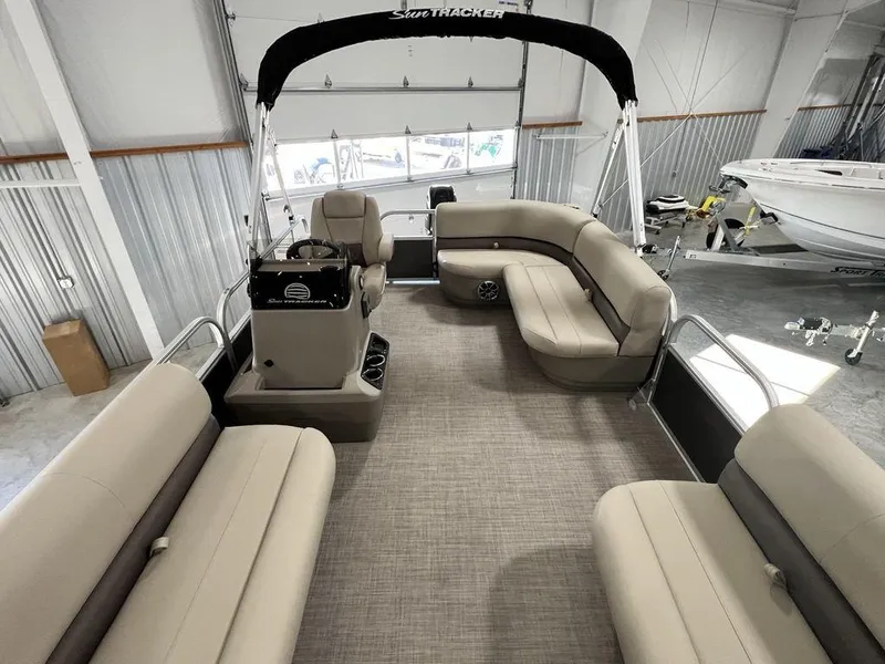 Slide: The Image of 2025 Sun Tracker PARTY BARGE® 16 DLX pontoon boat interior with beige seating and helm. - 17