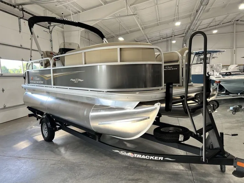 Slide: The Image of 2025 Sun Tracker PARTY BARGE® 16 DLX pontoon boat on trailer in indoor showroom. - 3