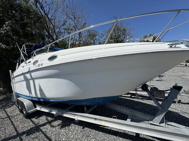 Slide: The Image of 2002 Sea Ray 260 Sundancer boat on trailer, parked outdoors under clear sky. - 1