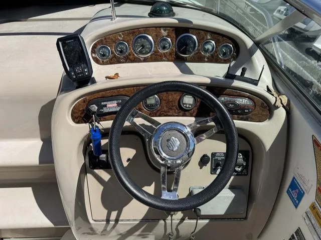Slide: The Image of Dashboard of a 2002 Sea Ray 260 Sundancer boat with steering wheel and gauges. - 11