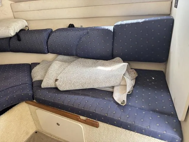 Slide: The Image of Interior seating of 2002 Sea Ray 260 Sundancer with blue cushions and folded fabric. - 15