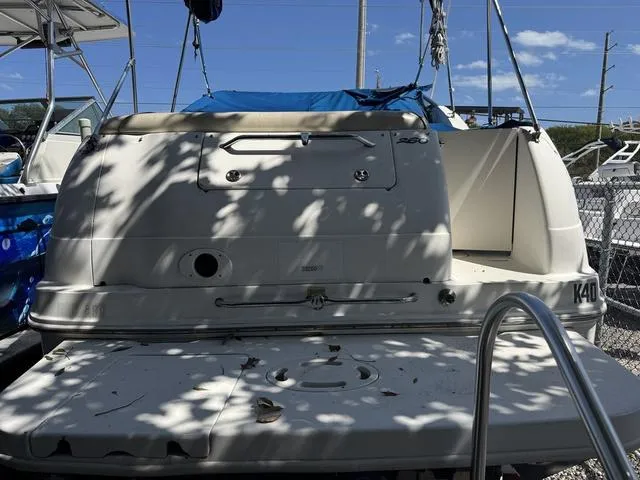 Slide: The Image of 2002 Sea Ray 260 Sundancer boat docked, rear view with shadows and clear sky. - 2