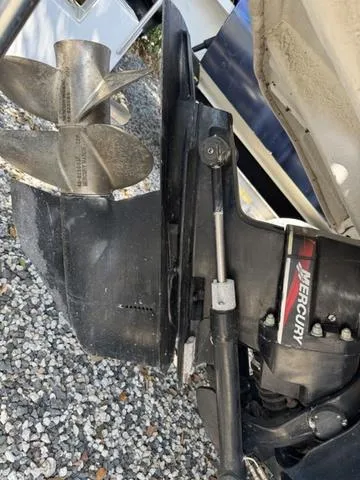 Slide: The Image of 2002 Sea Ray 260 Sundancer boat engine with Mercury propeller on gravel. - 3