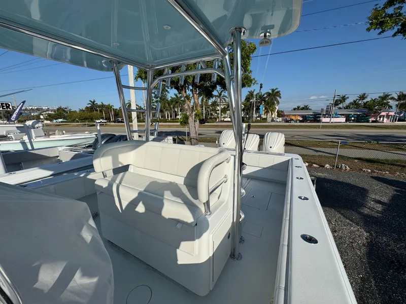 Slide: The Image of 2024 Contender 39 ST boat with white seating and canopy, parked outdoors. - 13