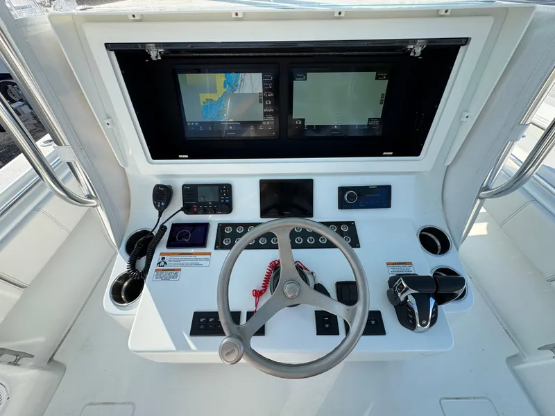 Slide: The Image of 2024 Contender 39 ST helm with dual displays, steering wheel, and navigation controls. - 18