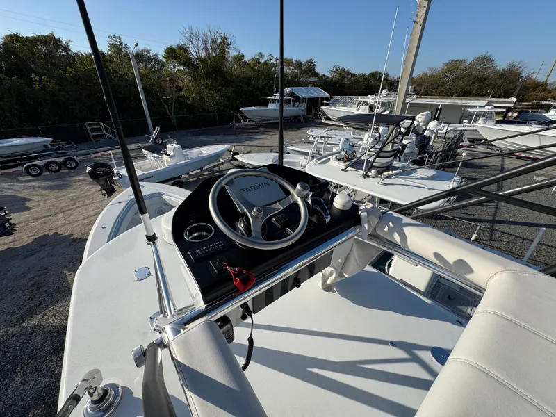 Slide: The Image of 2024 Contender 39 ST boat helm with steering wheel and controls, docked outdoors. - 21