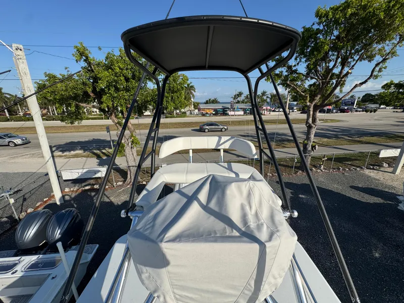 Slide: The Image of 2024 Contender 39 ST boat with covered seating and T-top, parked outdoors. - 23