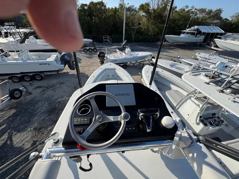 Slide: The Image of 2024 Contender 39 ST boat dashboard with Garmin navigation, surrounded by other boats. - 24