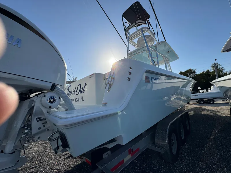 Slide: The Image of 2024 Contender 39 ST boat on trailer, sunlit, with triple engines. - 8