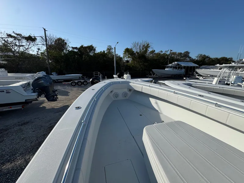 Slide: The Image of 2024 Contender 39 ST boat, spacious deck, parked outdoors under clear blue sky. - 9