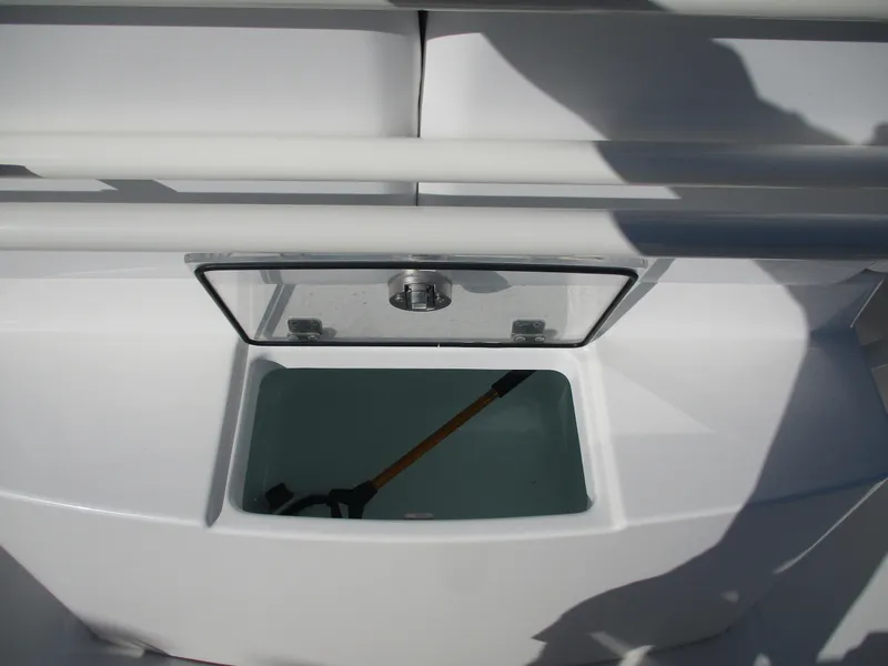 Slide: The Image of 2020 Regulator 26XO boat storage compartment with transparent lid and visible interior. - 11