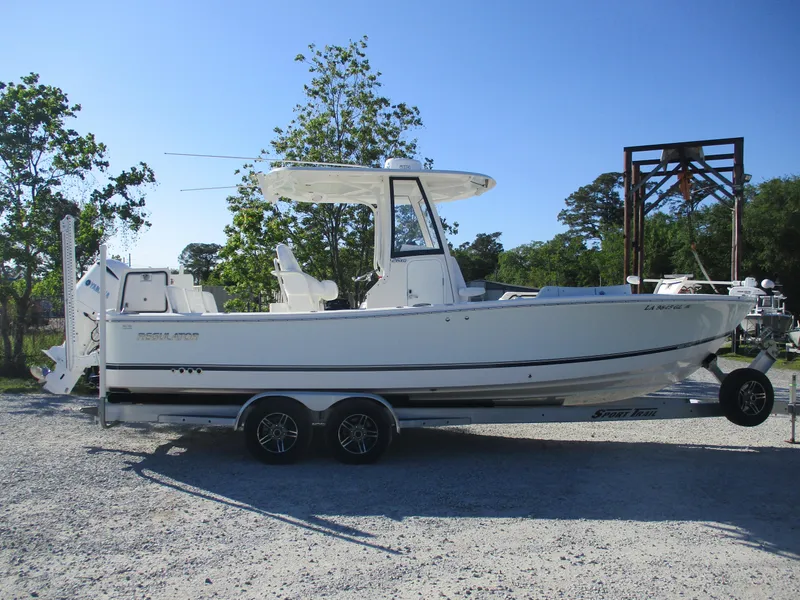 Slide: The Image of 2020 Regulator 26XO boat on a trailer, parked outdoors on gravel. - 3