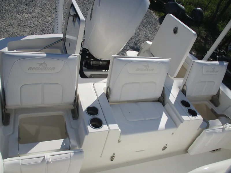 Slide: The Image of 2020 Regulator 26XO boat seating and storage compartments, featuring cup holders and white upholstery. - 5