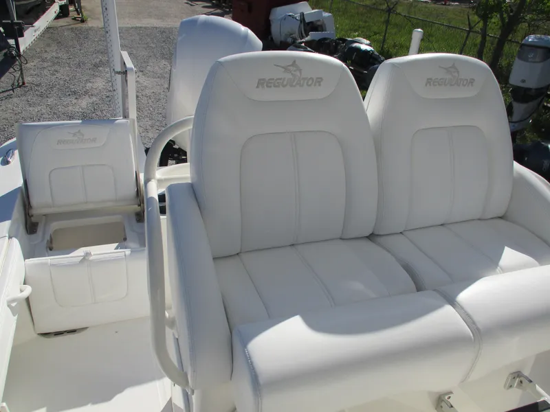Slide: The Image of 2020 Regulator 26XO boat with white cushioned seating and storage compartment. - 7