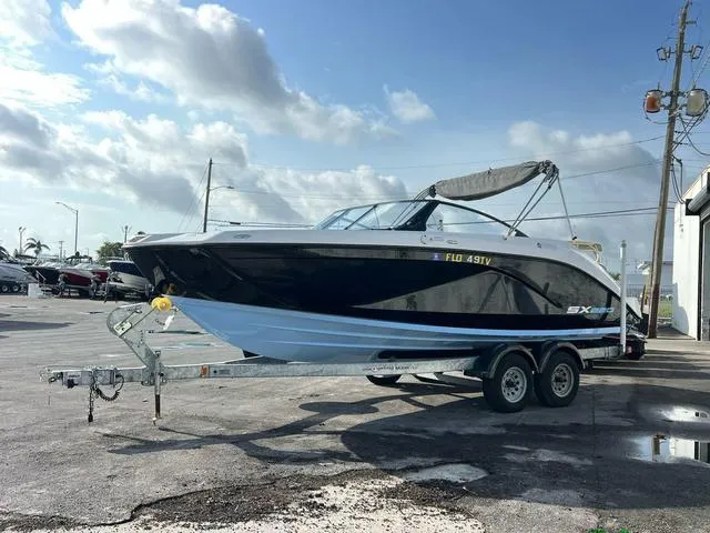 Slide: The Image of 2024 Yamaha Boats SX220 on trailer, parked outdoors under a cloudy sky. - 1