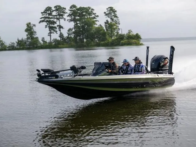 Slide: The Image of 2025 Skeeter FXR20 PRO boat speeding on a lake with three passengers. - 1