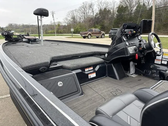 Slide: The Image of 2024 Nitro Z21 XL Pro boat interior with steering console and seating, parked outdoors. - 12