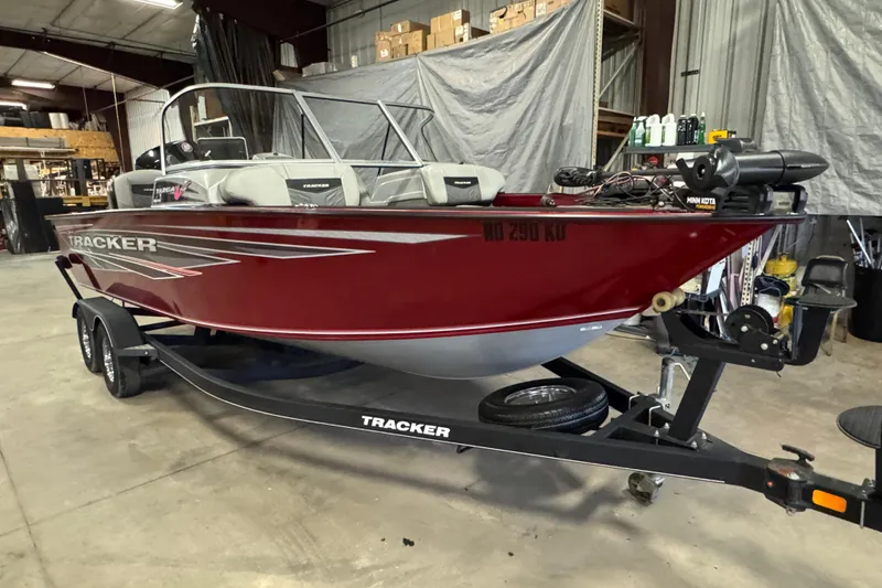 Slide: The Image of 2019 Tracker Targa V-19 Combo boat in a garage, red exterior, on a trailer. - 2